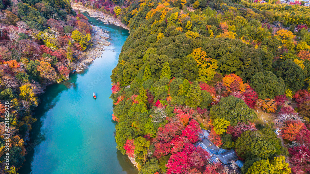 Fototapeta premium Widok z lotu ptaka na rzece pozwala turystom cieszyć się jesiennymi kolorami wzdłuż rzeki Katsura do gór Arashiyama w sezonie jesiennym w Arashiyama w Kioto w Japonii.