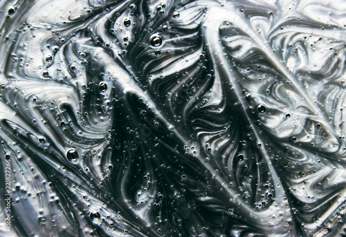 Mix of a white and black paint, closeup. The texture of the poured paint.