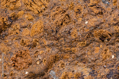 Colorful abstract background of volcanic tuff rock. Warm colored volcanic tuff often used for decoration in a garden.