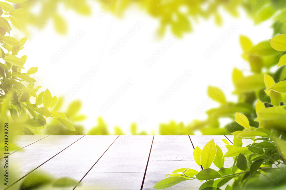 Fotografie wooden table top with spring green leafs as frame