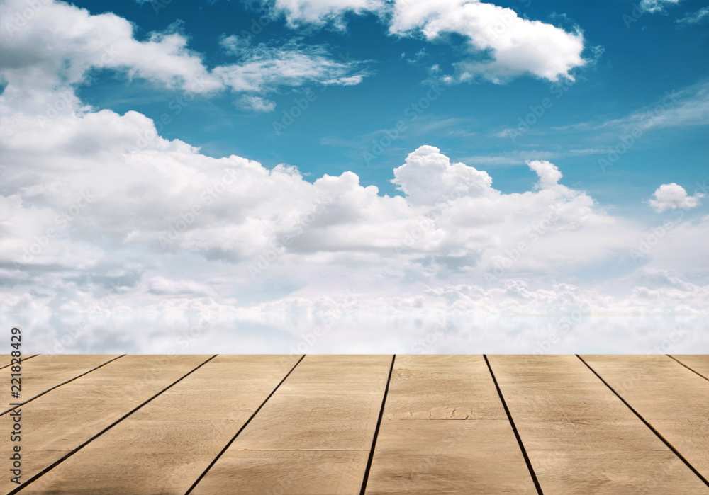 wooden table top with blue sky reflective on water