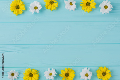Flowers on borders composition. Copyspace, flat lay, blue wooden background. © DenisProduction.com
