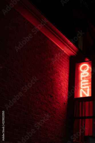 Neon Open sign in red on brick wall