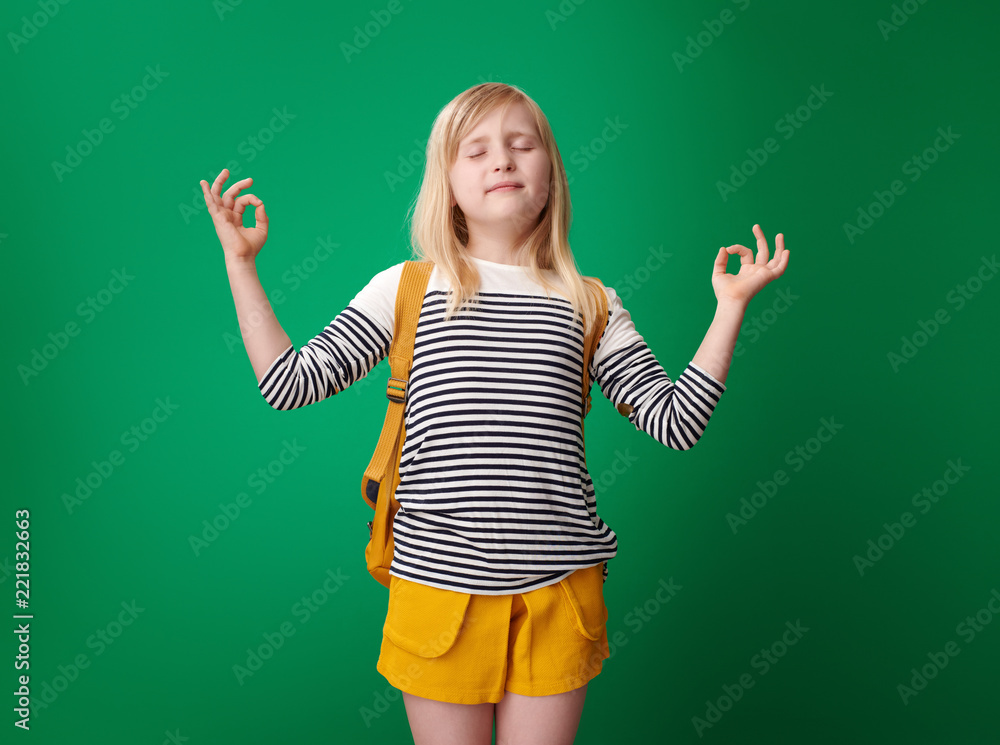 relaxed school girl doing yoga isolated on green background relaxed school girl doing yoga isolated on green background