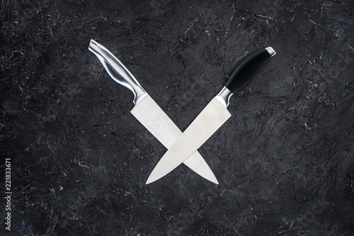 Fotografie top view of two kitchen knives arranged on black surface