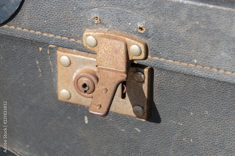 A close up front view of an old rusted travel suitcase lock A close up front view of an old rusted travel suitcase lock
