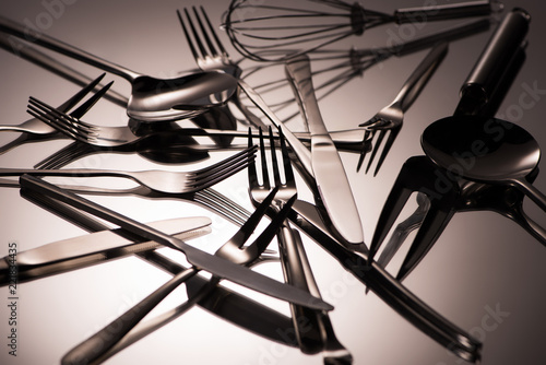 close-up view of various shiny stainless steel utensils on grey © LIGHTFIELD STUDIOS