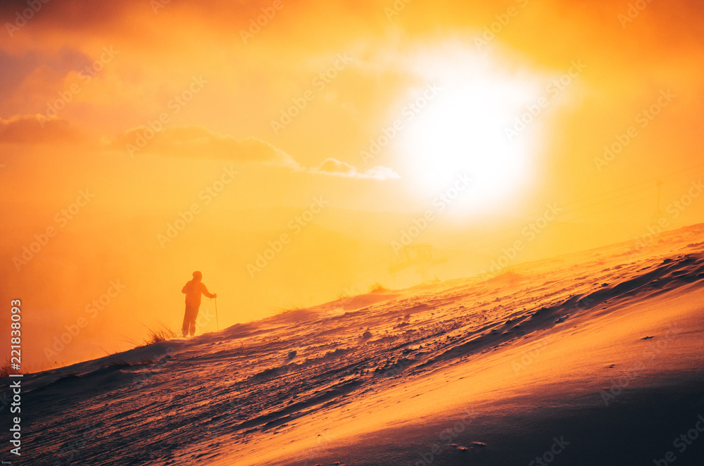 Skier and orange sunset, edit space