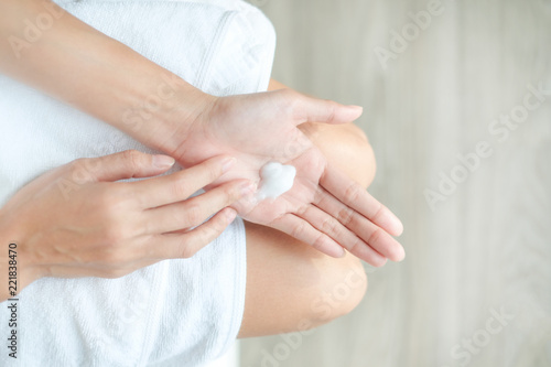 Woman applying moisturizing cream/lotion on hands, beauty concept.