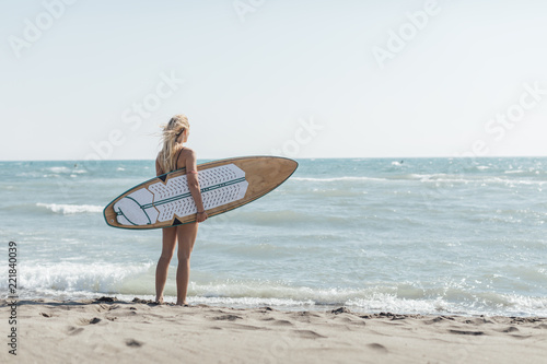 A Woman Surfer Standing at Beach photo