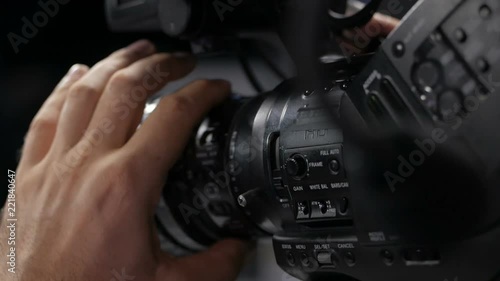 The cameraman is working behind the camera.