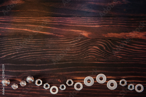 washers, nuts and bolts on wooden table.