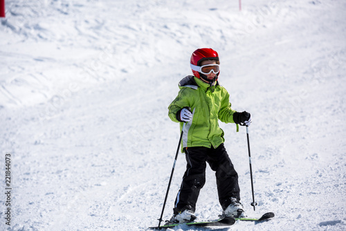 Happy child learns to ski on the ski slopes
