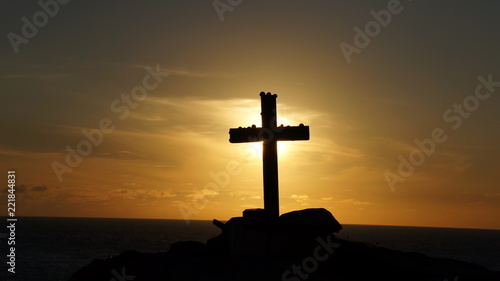Silhouette of Cross Crucifix against a Golden Sunset