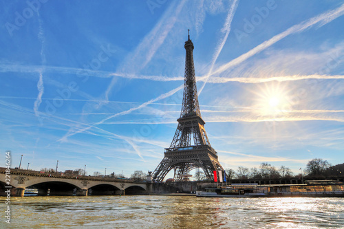 Beautiful backlit Eiffel tower at the Seine river with a dramatic sky in winter photo