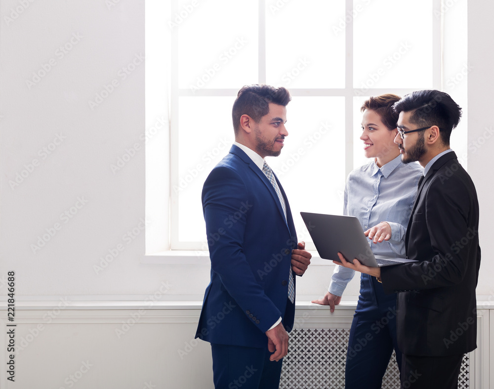 Business colleagues having conversation in office near window Business colleagues having conversation in office near window