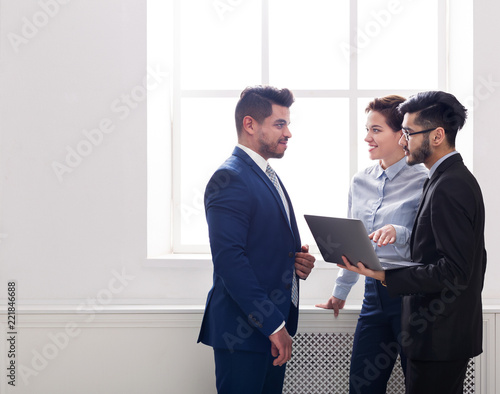 Business colleagues having conversation in office near window