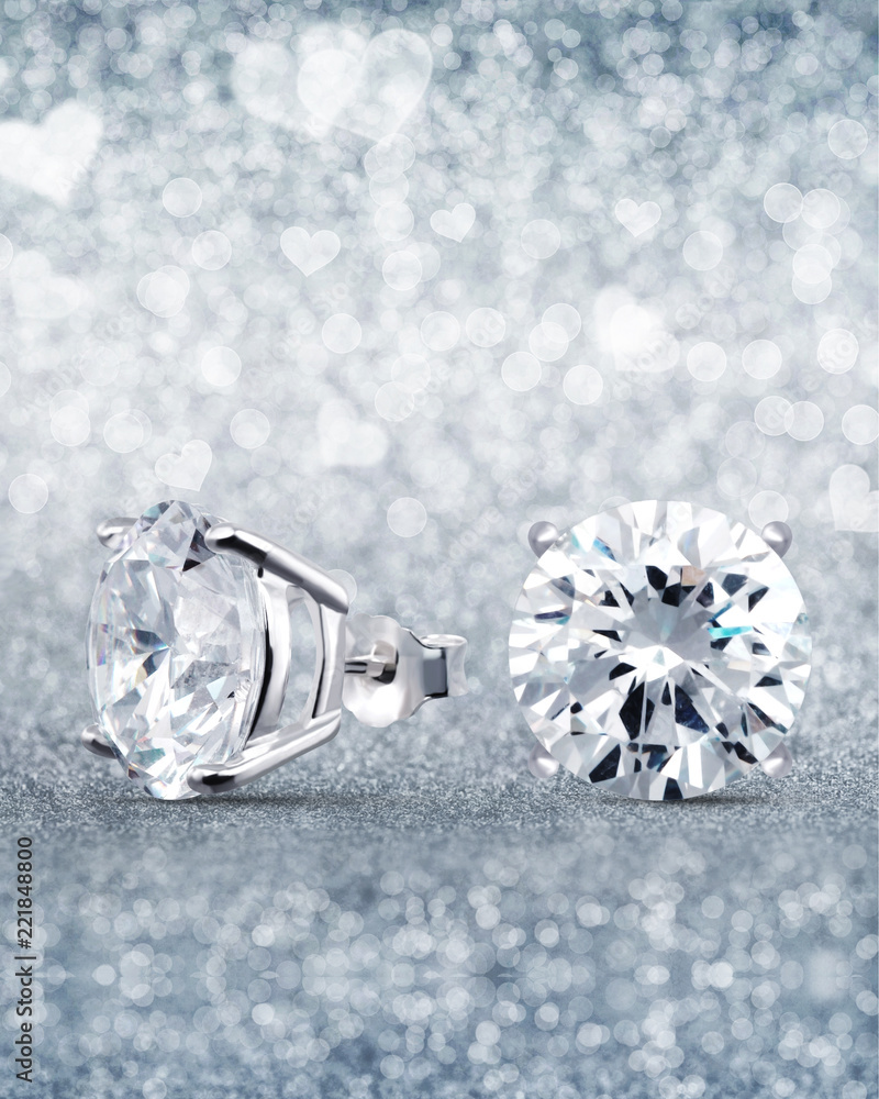 beautiful white diamond stud earrings with reflection on background beautiful white diamond stud earrings with reflection on background