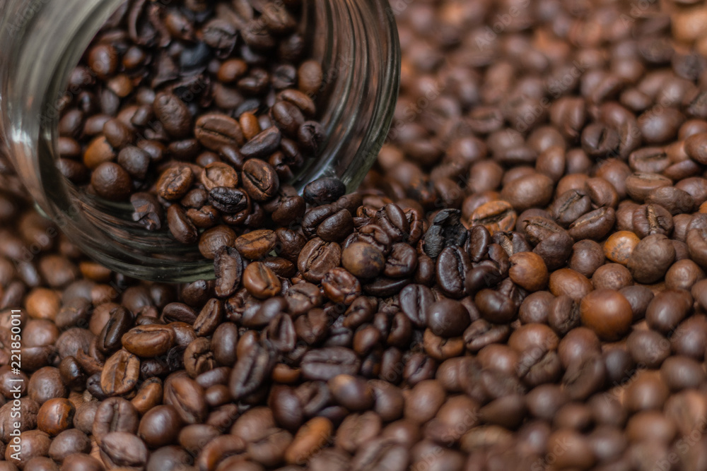 Coffee beans, poured from a glass transparent jar. Coffee beans, poured from a glass transparent jar.