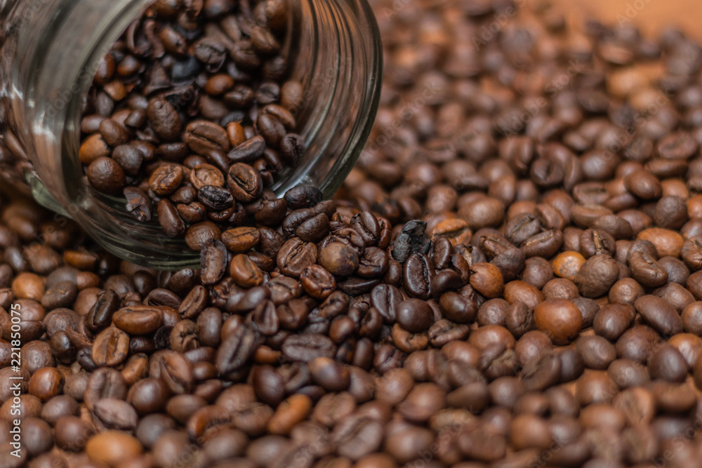 Coffee beans, poured from a glass transparent jar. Coffee beans, poured from a glass transparent jar.