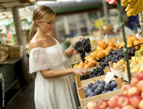 Young woman buying fruits on the market