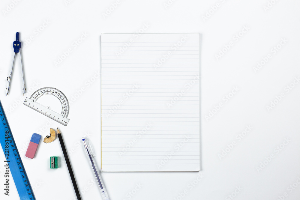 A photo of stationery set: pencil, rubber, sharpener, compass, protractor, ruler on the white background on the table . Workspace of student or office worker. A photo of stationery set: pencil, rubber, sharpener, compass, protractor, ruler on the white background on the table . Workspace of student or office worker.