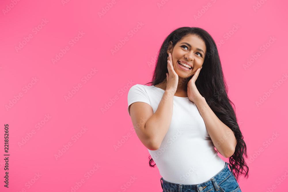 portrait of smiling dreamy african american woman looking away isolated on pink portrait of smiling dreamy african american woman looking away isolated on pink