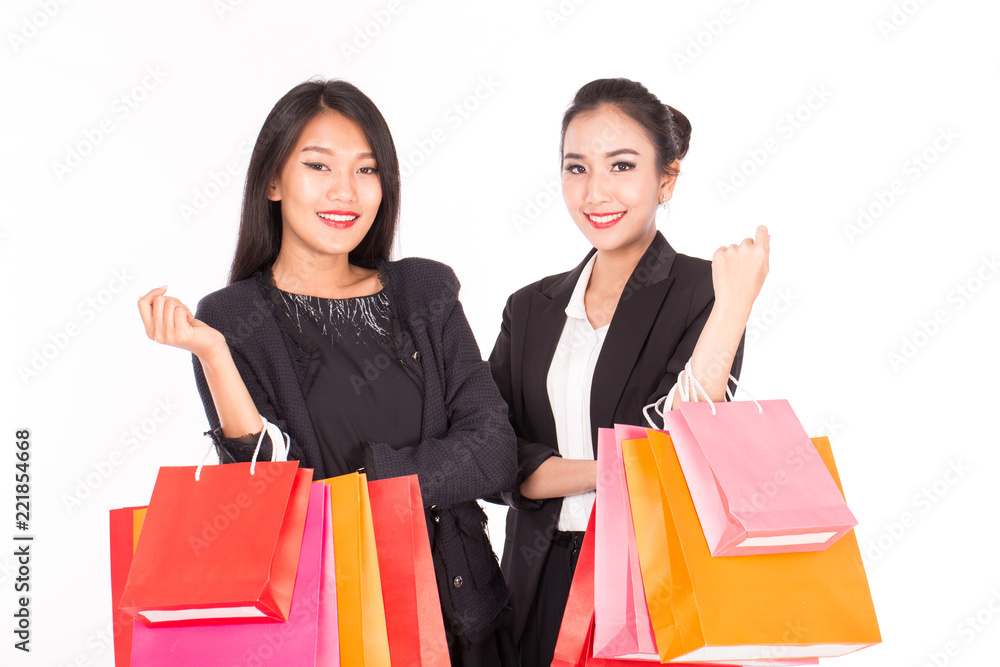 Beautiful Attractive two Asian women friends holding shopping bags in hands and smile after Shopping in Black Friday Sale feeling so happiness and cheerful isolated on white background Beautiful Attractive two Asian women friends holding shopping bags in hands and smile after Shopping in Black Friday Sale feeling so happiness and cheerful isolated on white background
