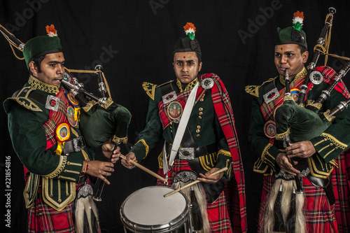 Two pipers and snare drummer of an Indian American Scottish bagpipe band in full Scottish regalia, including kilts and sporrans photo