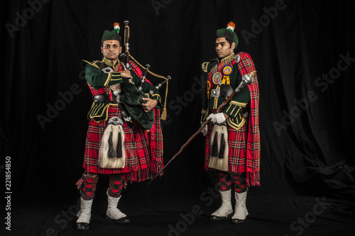 Drum major and piper of an Indian American Scottish bagpipe looking at camera in full Scottish regalia, including kilts and sporrans photo