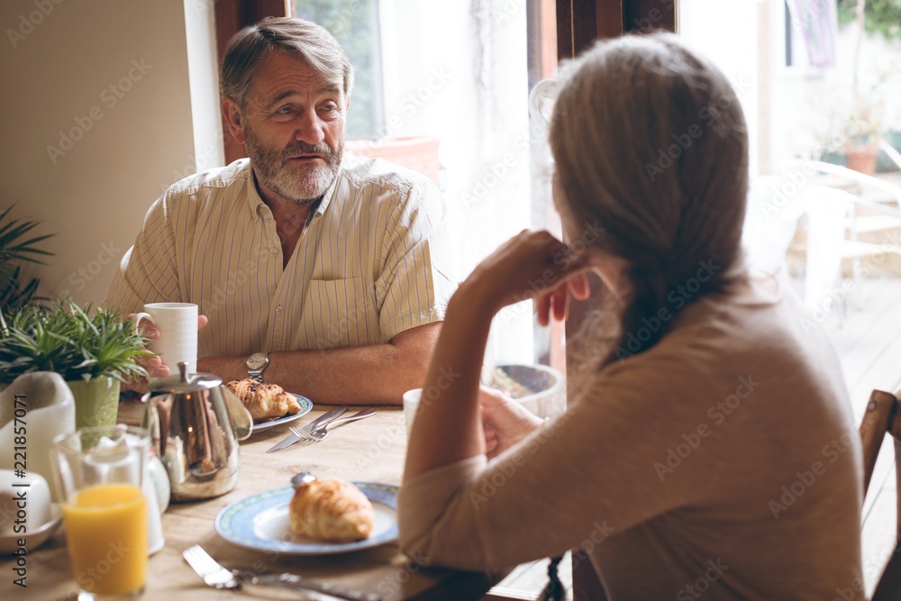 Senior couple interacting with each other while having breakfast Senior couple interacting with each other while having breakfast