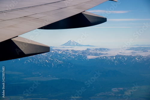 Mountains and volcanoes under the wing of an airplane
