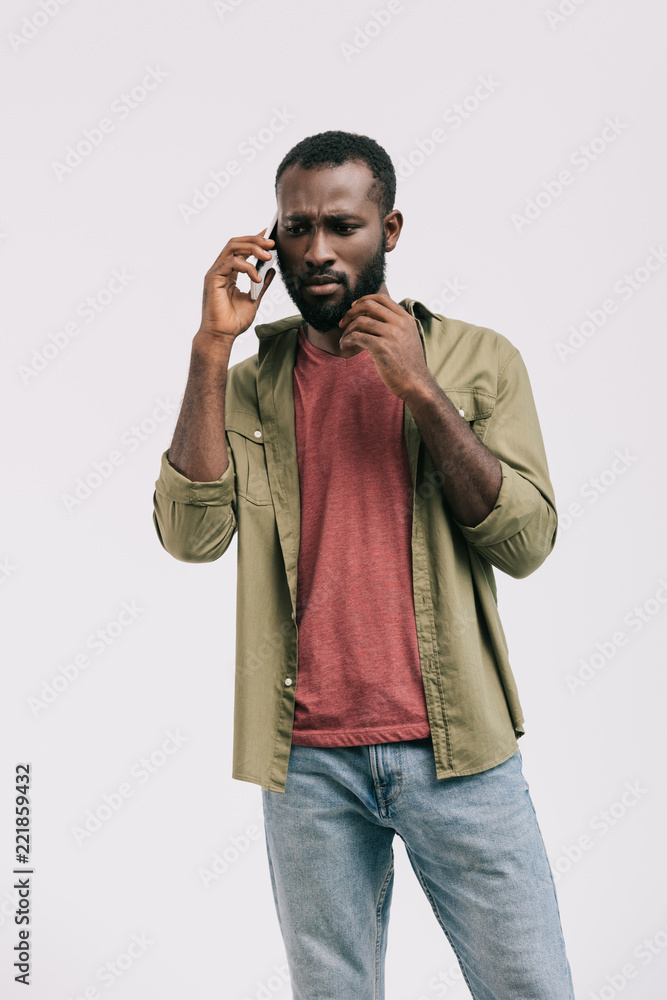 worried handsome african american man talking by smartphone isolated on white worried handsome african american man talking by smartphone isolated on white