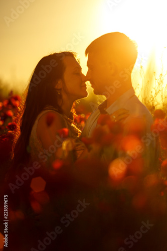 man and woman in poppy field at sunset, romance
