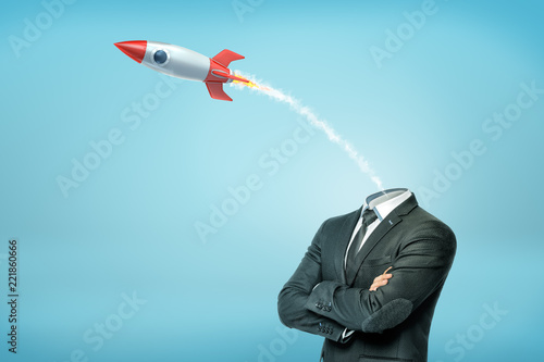 Photography A businessman with crossed arms and with a small launched old-school rocket instead of his head
