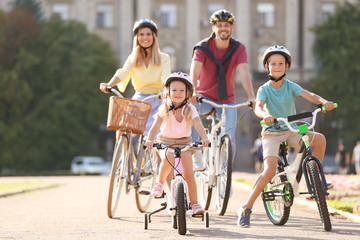 Happy family riding bicycles outdoors on summer day