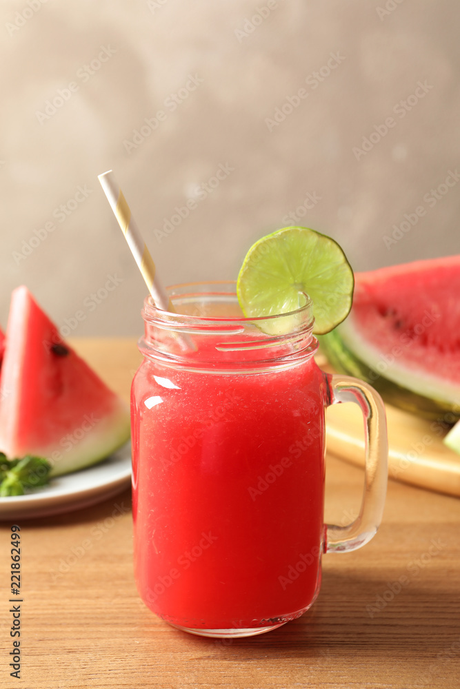Summer watermelon drink in mason jar and sliced fruit on table Summer watermelon drink in mason jar and sliced fruit on table