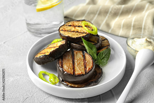 Plate with fried eggplant slices on table
