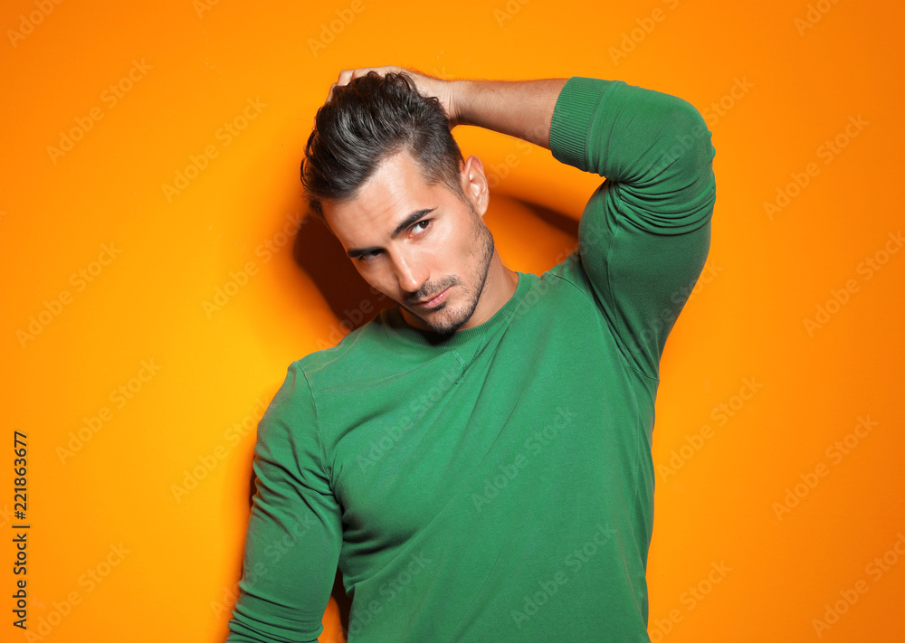 Young man with trendy hairstyle posing on color background Young man with trendy hairstyle posing on color background