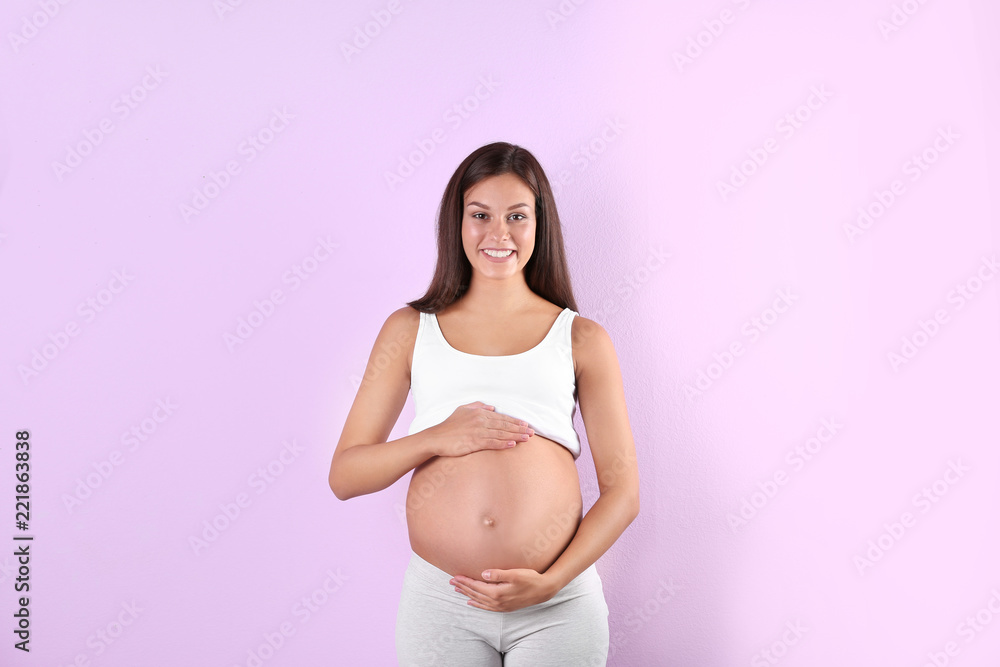 Happy pregnant woman posing on color background Happy pregnant woman posing on color background