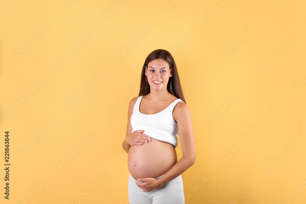 Happy pregnant woman posing on color background Happy pregnant woman posing on color background