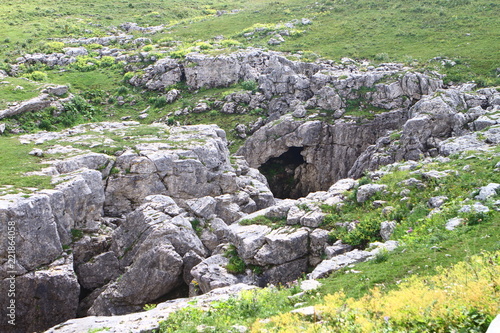 Natural landscape photo - deep dark cave on a mountain slope.