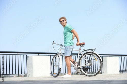 Handsome young man with bicycle outdoors on sunny day © New Africa