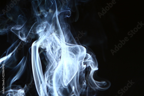 beautiful abstract contrast blue smoke against the heavy black background.