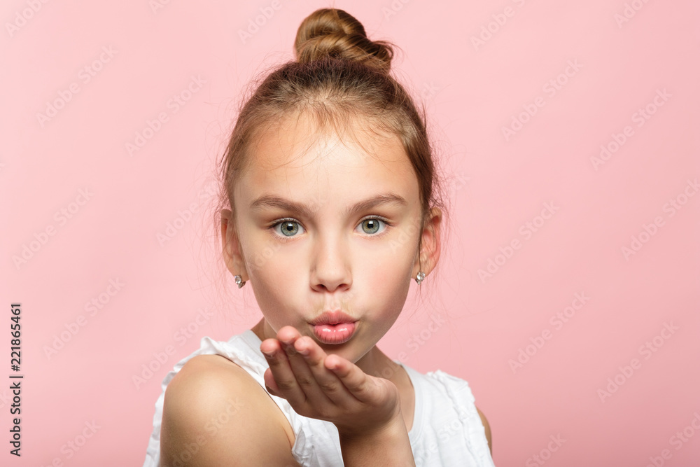 cute little girl blowing a kiss. pretty young child sending love. romance and warm feelings concept. portrait on pink background. cute little girl blowing a kiss. pretty young child sending love. romance and warm feelings concept. portrait on pink background.