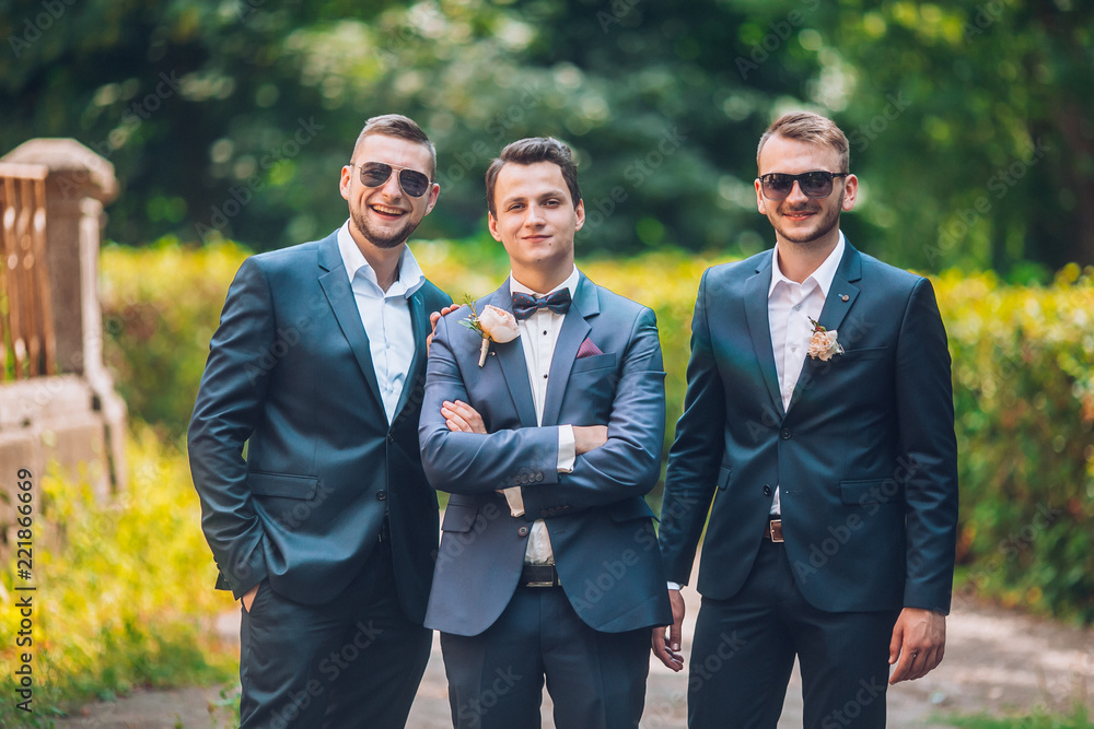 Groomsmen and groom posing outdoors on the wedding day. Funny wedding moment for best groom friends. Mens hug each other. Groomsmen and groom posing outdoors on the wedding day. Funny wedding moment for best groom friends. Mens hug each other.