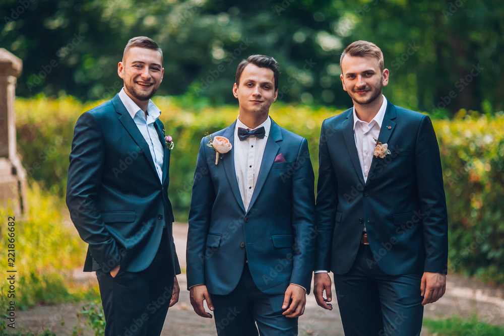 Groomsmen and groom posing outdoors on the wedding day. Funny wedding moment for best groom friends. Mens hug each other. Groomsmen and groom posing outdoors on the wedding day. Funny wedding moment for best groom friends. Mens hug each other.