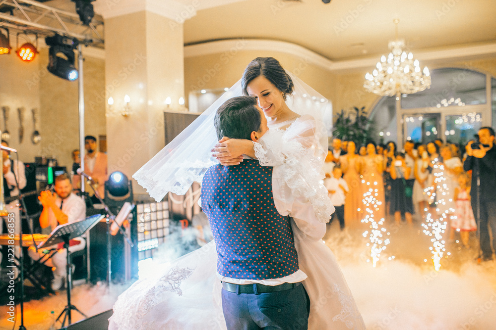 brides wedding party in the elegant restaurant with a wonderful light and atmosphere. Newlyweds dancing with fireworks.