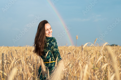 Happy woman in wheat field with Golden ears smiling, copy space