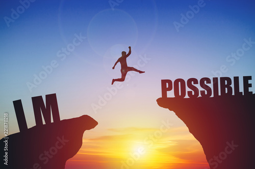 Man jumping on impossible text over cliff on sunset background photo